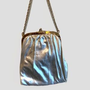 Beautiful metallic silver women’s purse with metal clutch and adornments.